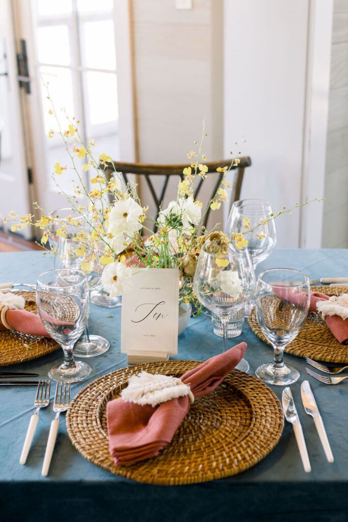 Wedding table with wicker charger plates and yellow flowers