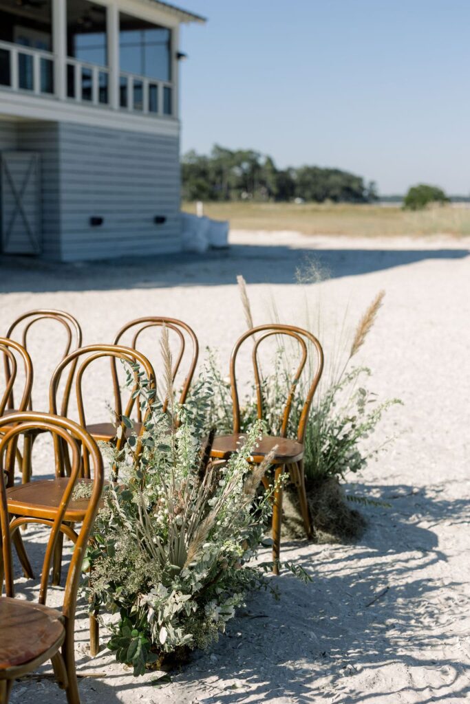 Brown chairs and ceremony wedding arrangements for a beach wedding
