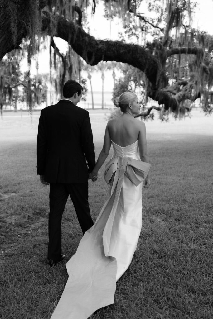 Black and white photo of bride and groom walking