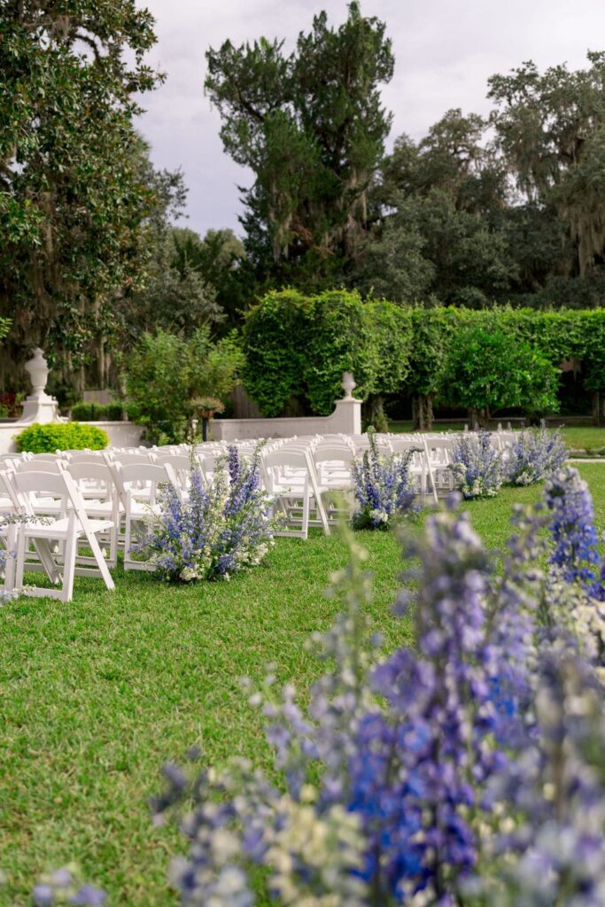 Wedding ceremony with blue and white flowers lining the aisle