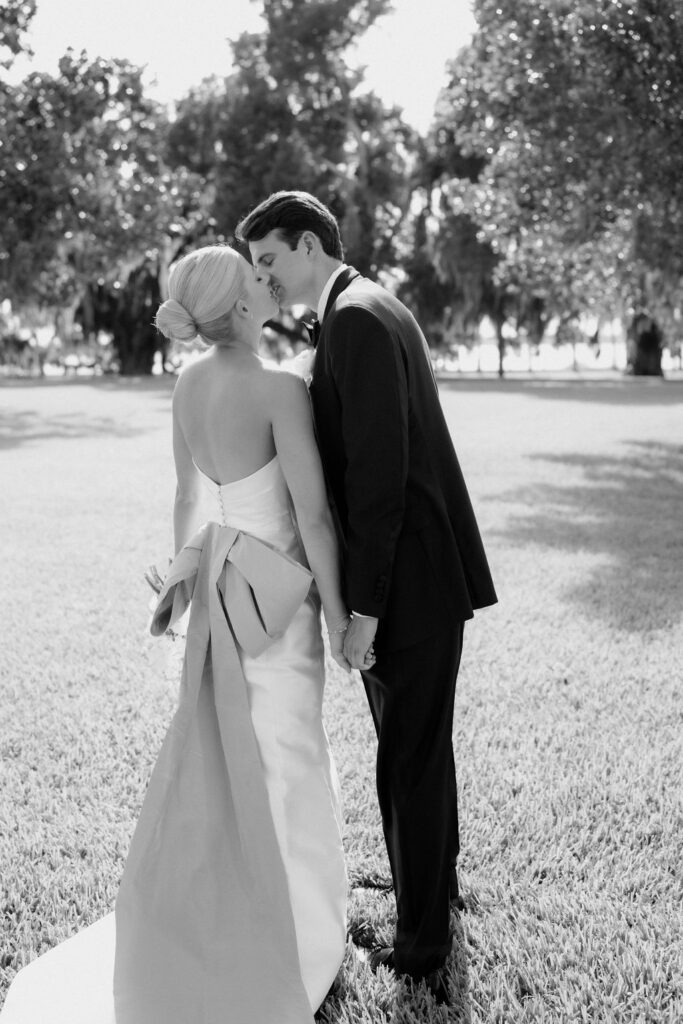 Black and white photo of bride and groom kisisng