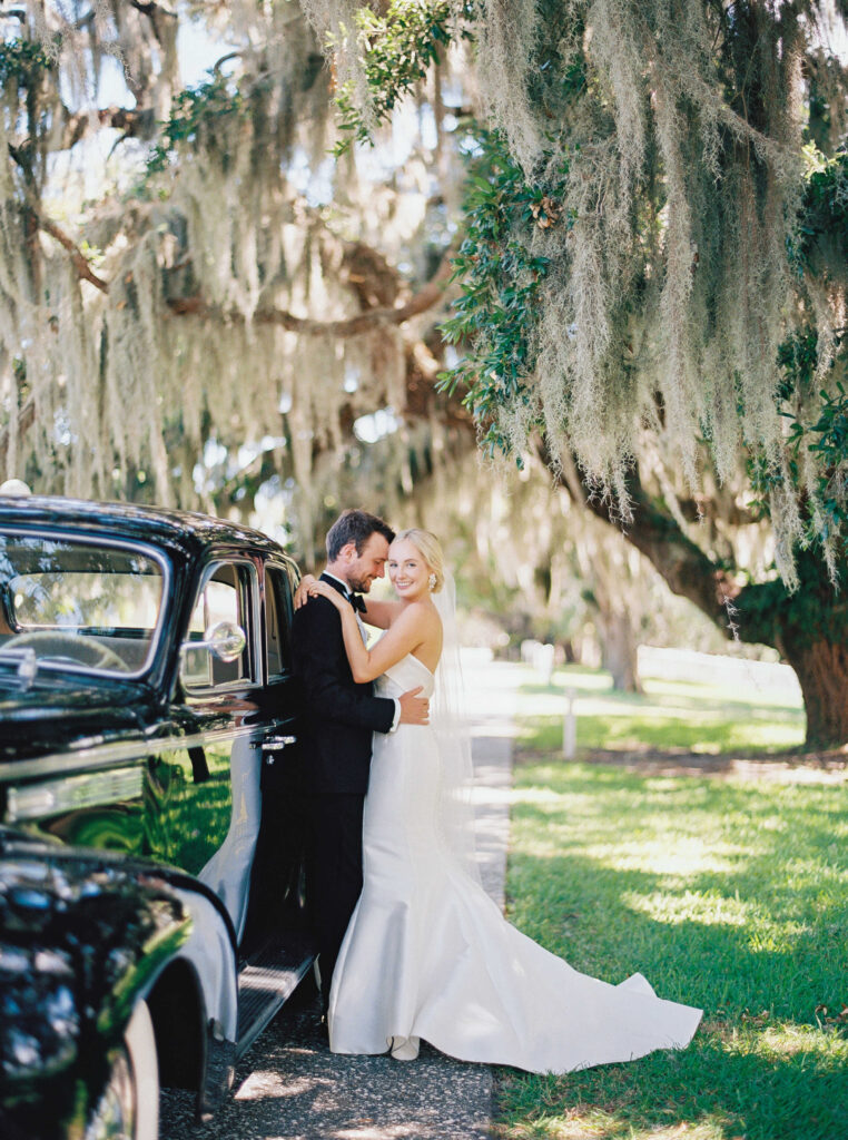 Bride and groom portrait in front of vintage car