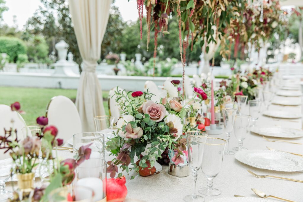 White wedding table with burgundy and mauve flowers