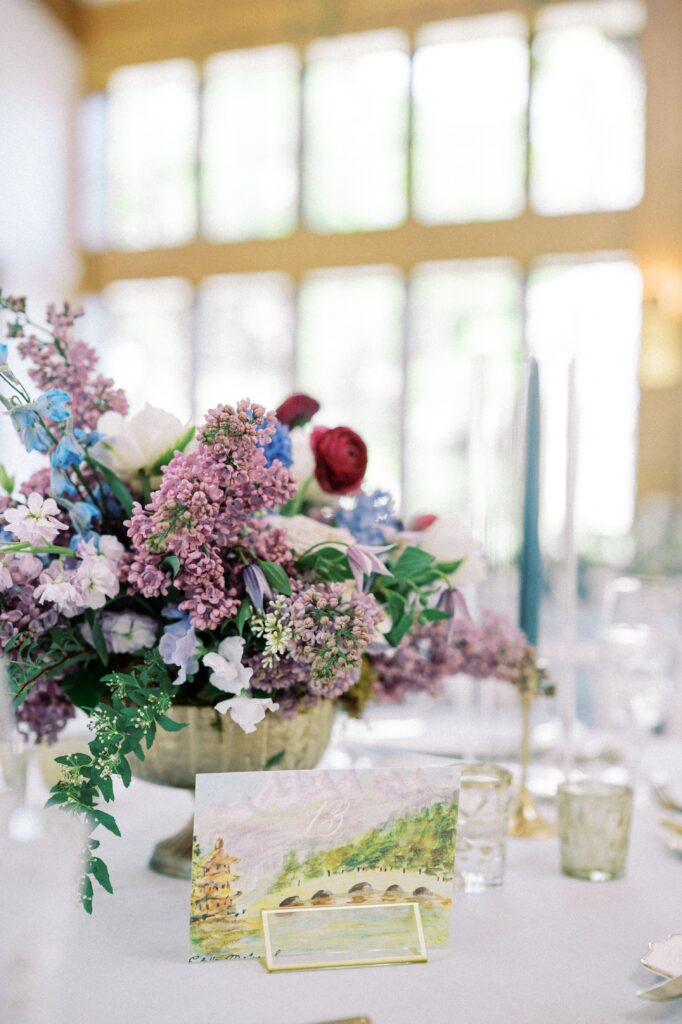 Purple and blue floral centrepiece and watercolor table number